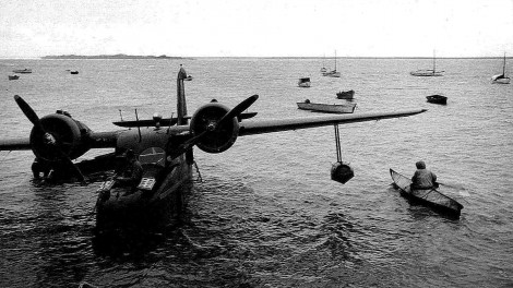 Bow-of-plane-and-eskimos-in-kayaks-vintage-old-photo